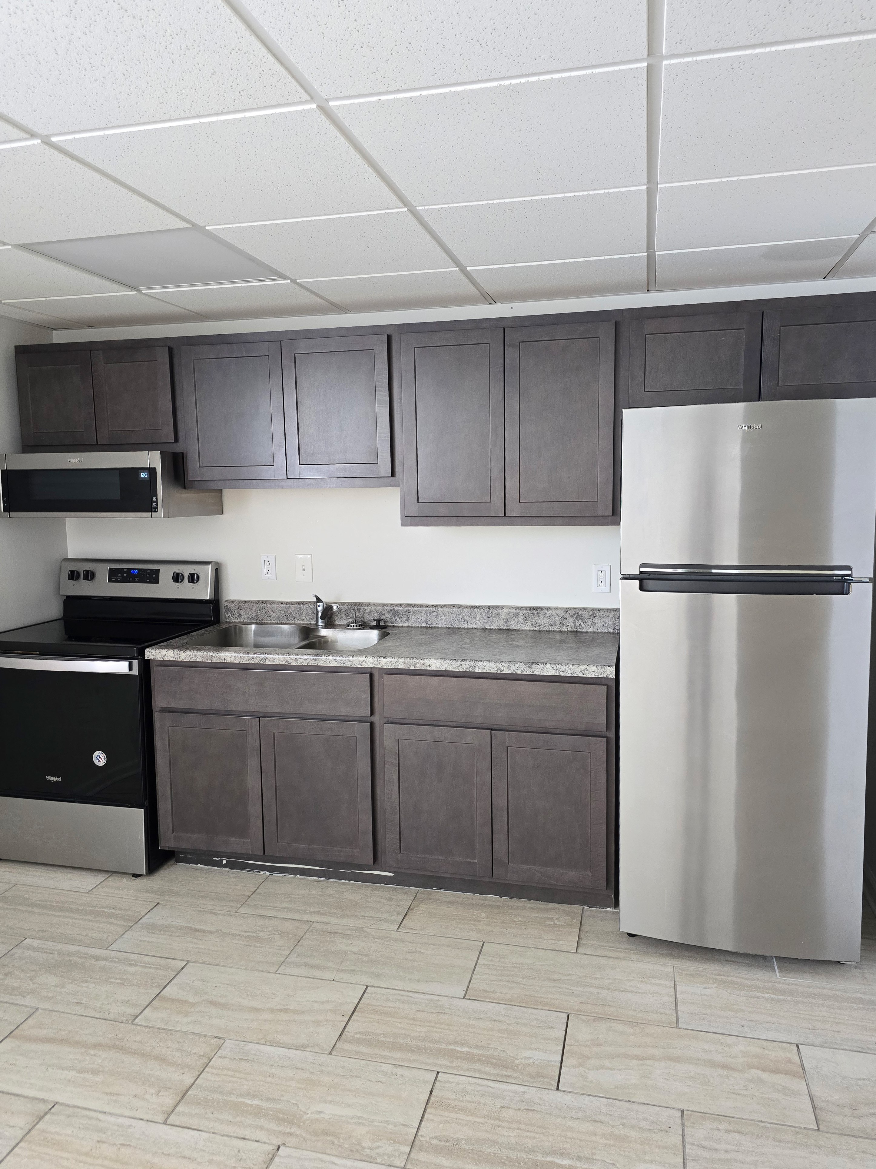 A kitchen with a white fridge and black oven.